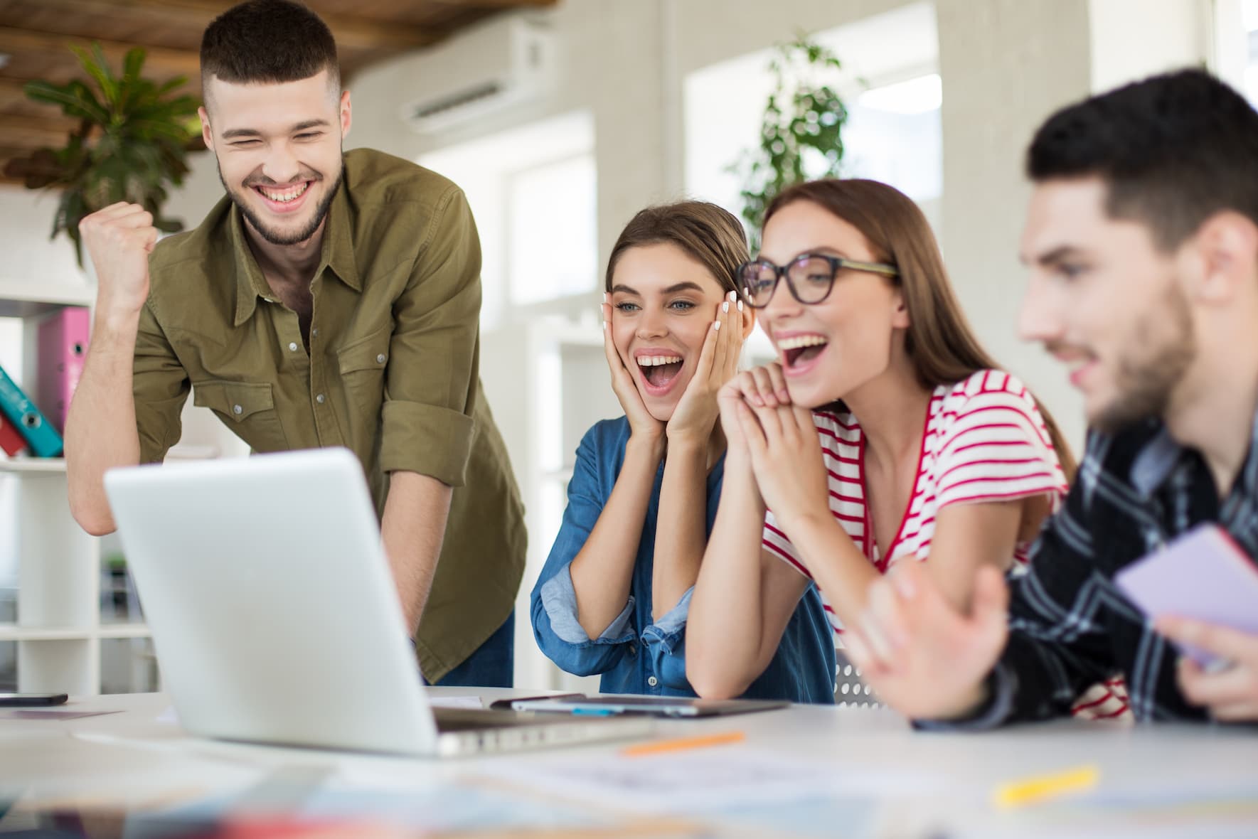 young-joyful-business-people-happily-working-laptop-together-group-smiling-men-women-spending-time-modern-cozy-office (1)
